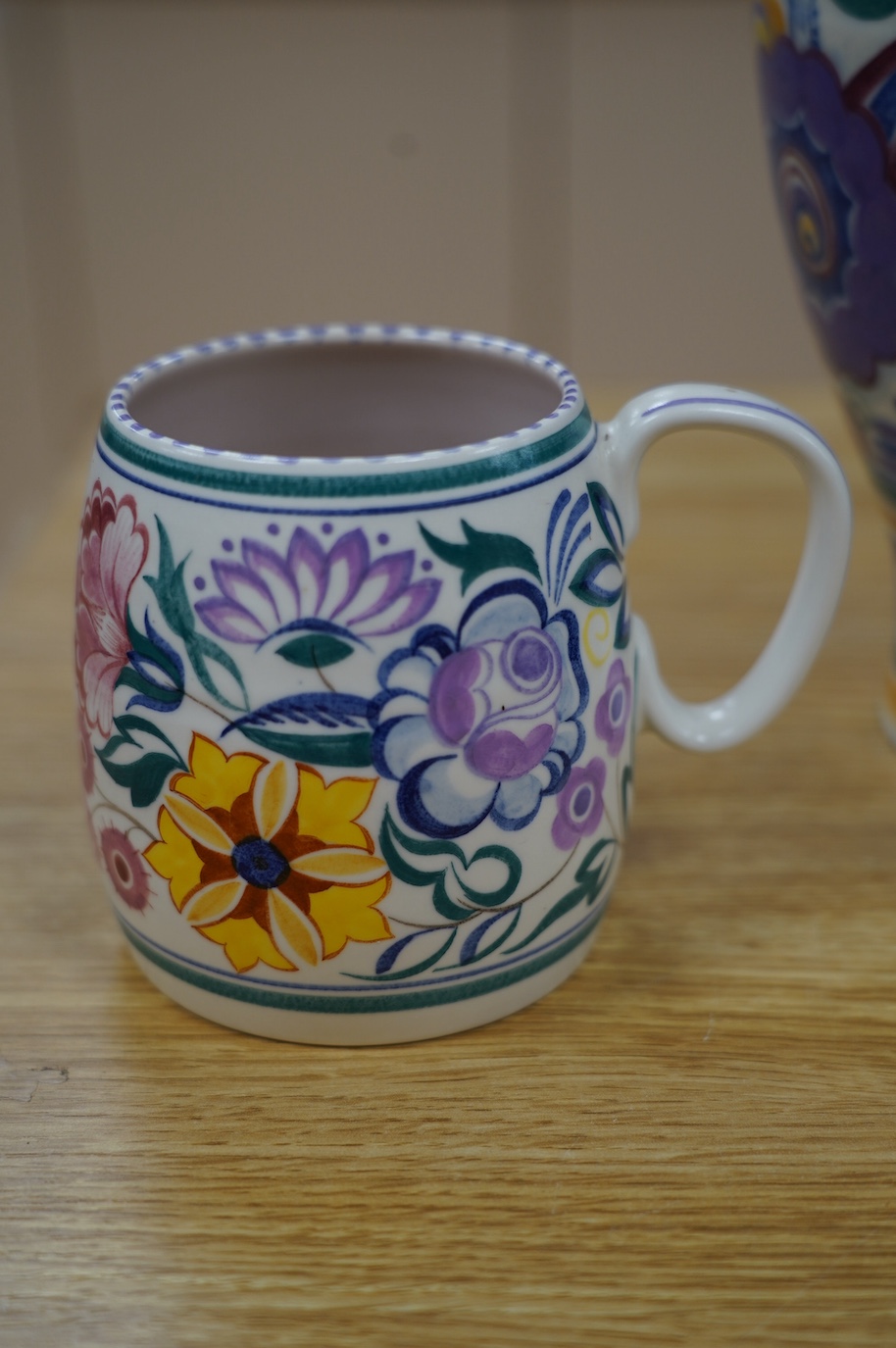 A 1930’s Poole pottery vase and a later mug, vase 25cm high. Condition - fair slight grazing to base rim of vase